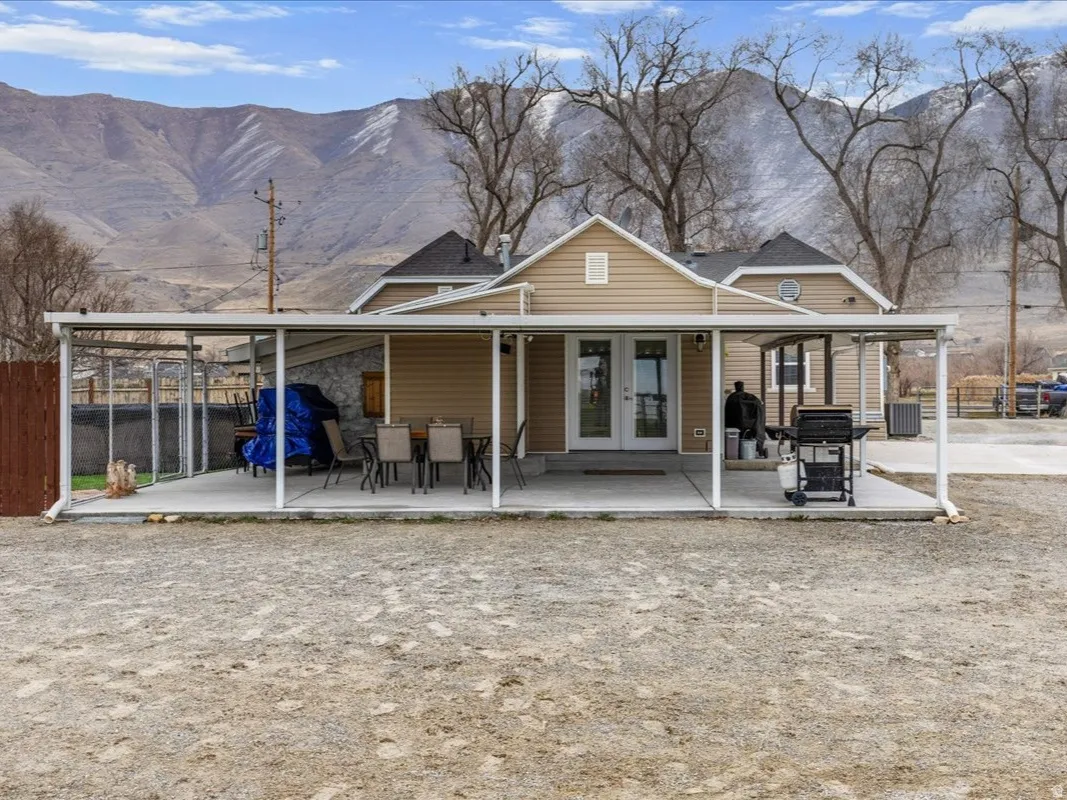 Back of house with french doors, a mountain view, and a patio