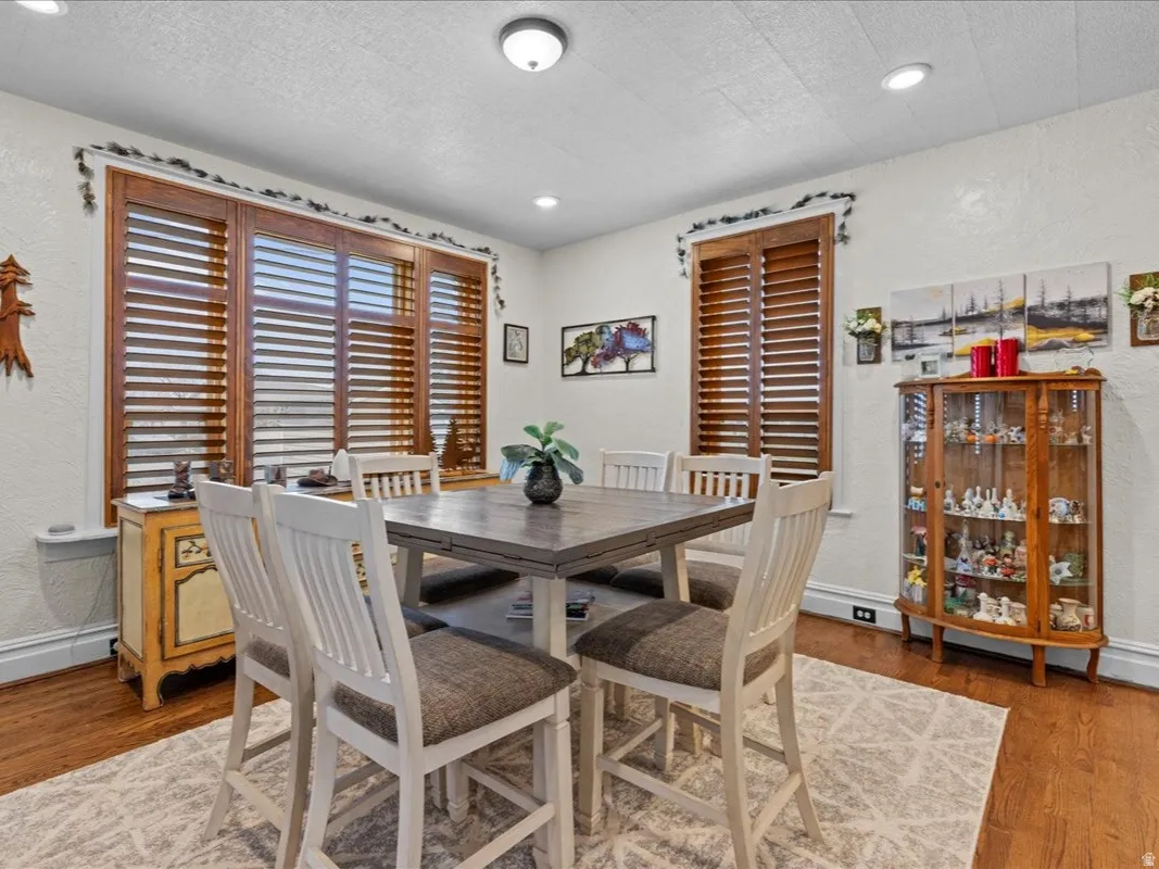 Dining area with a textured wall, wood finished floors, and a textured ceiling