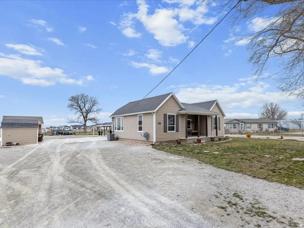 Bungalow-style home featuring a porch, a storage shed, driveway, and a front yard
