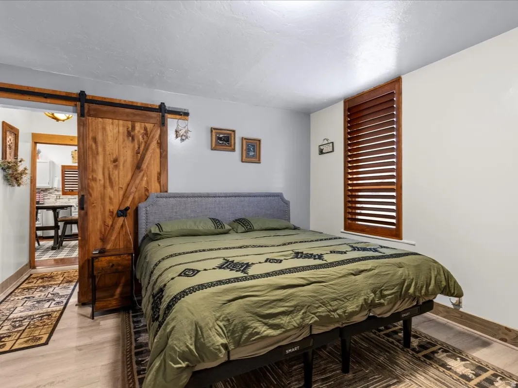Bedroom featuring a barn door and wood finished floors