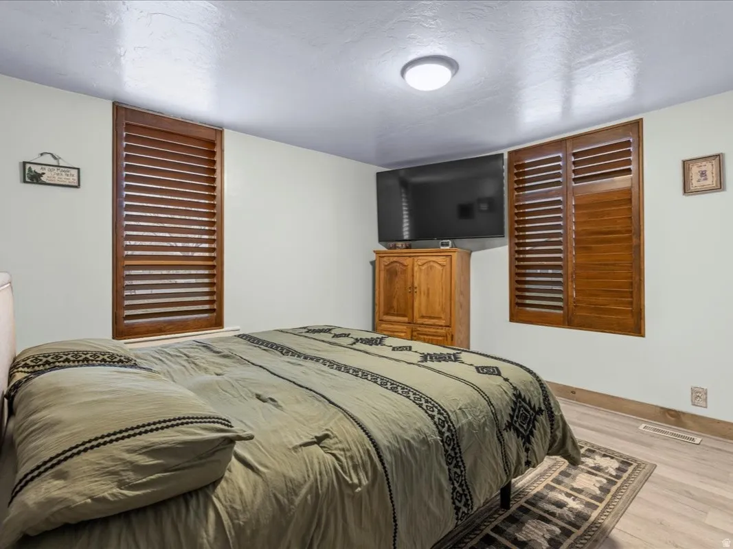 Bedroom featuring light wood-type flooring and a textured ceiling