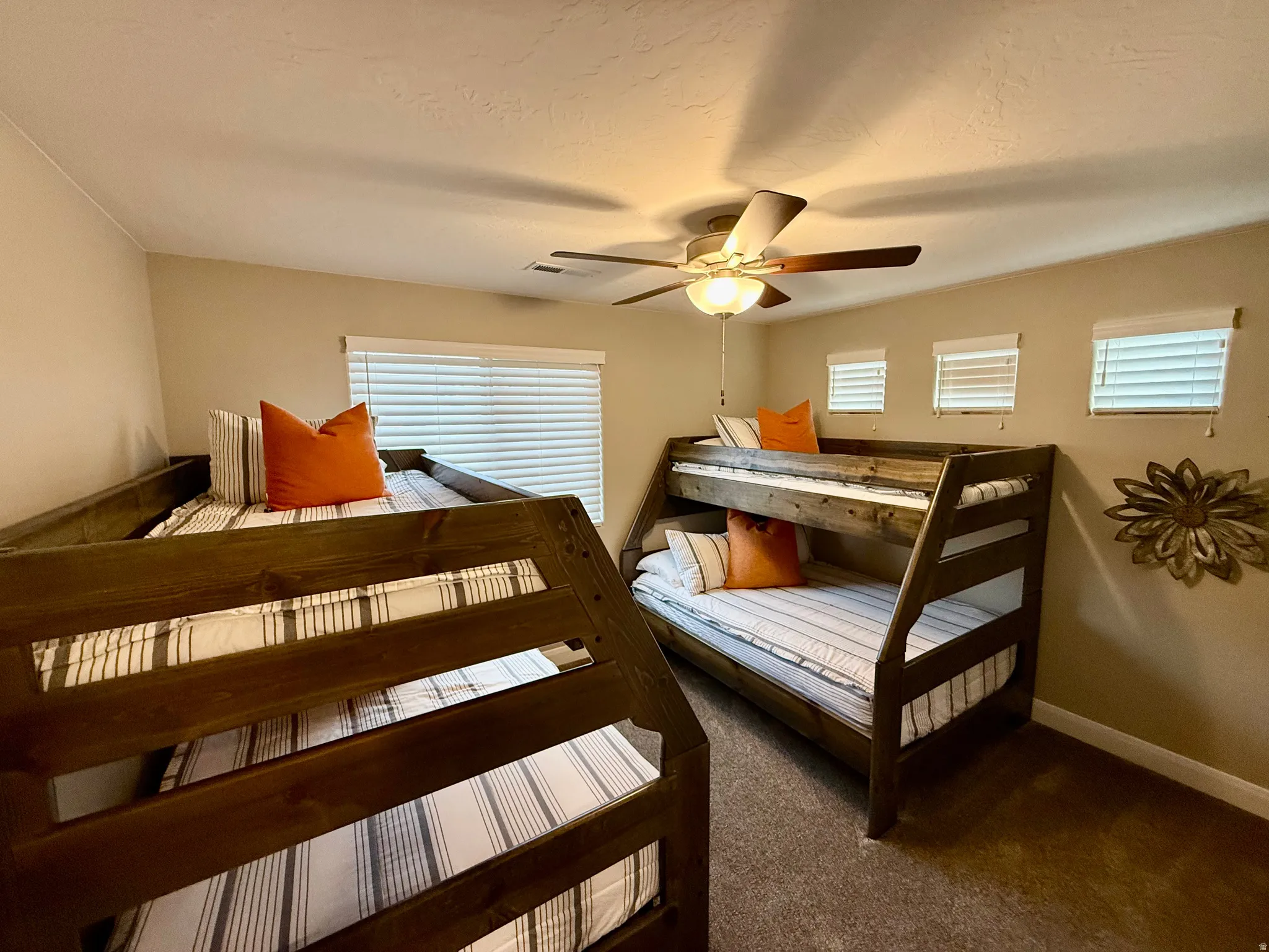 Bedroom featuring carpet floors, ceiling fan, and multiple windows