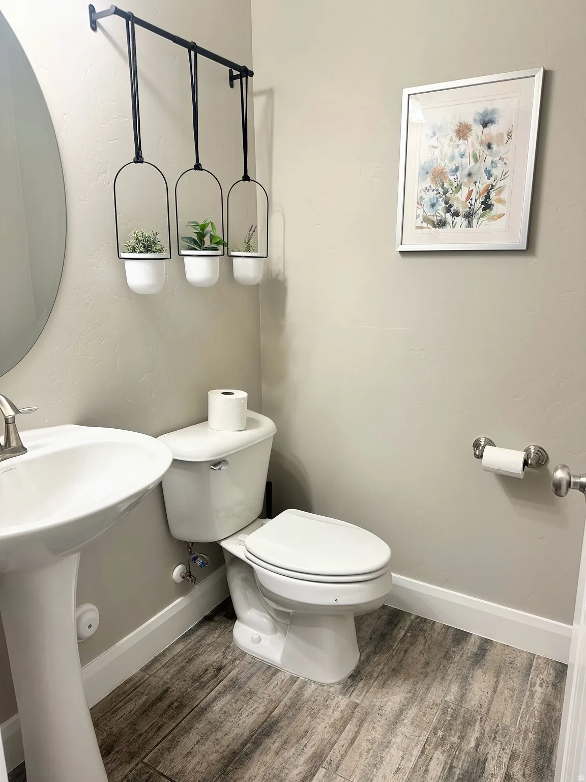 Half bath featuring toilet and wood finished floors