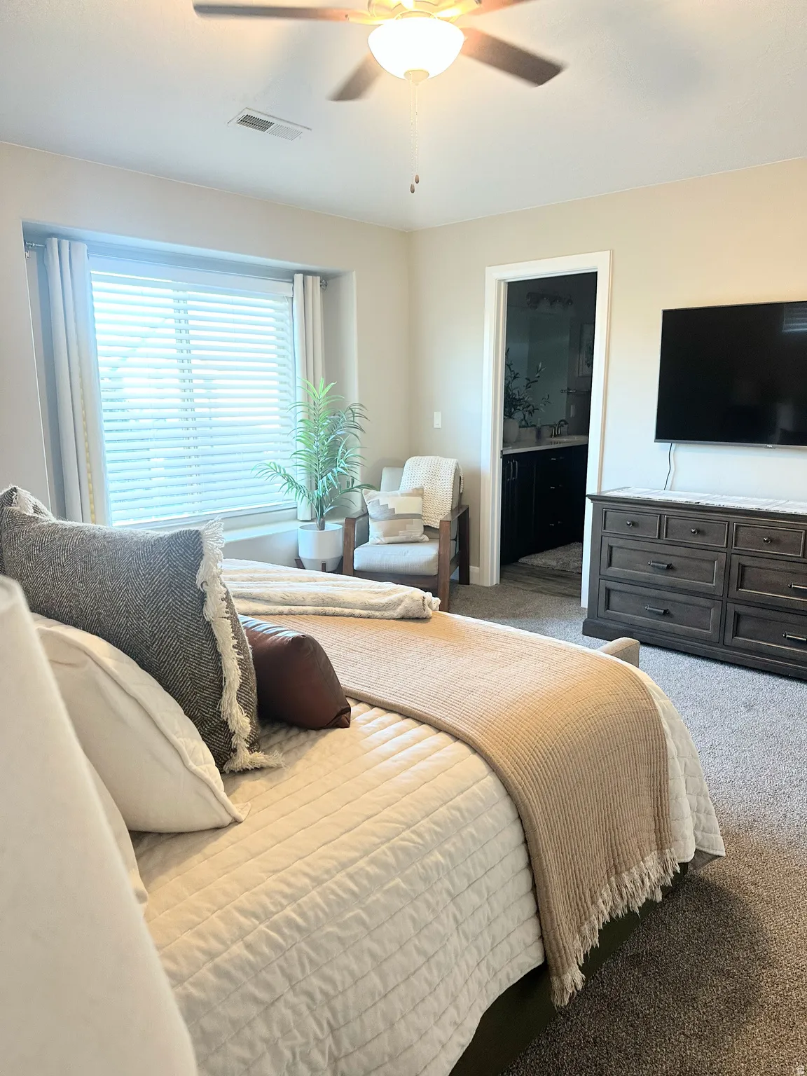 Carpeted bedroom featuring a ceiling fan