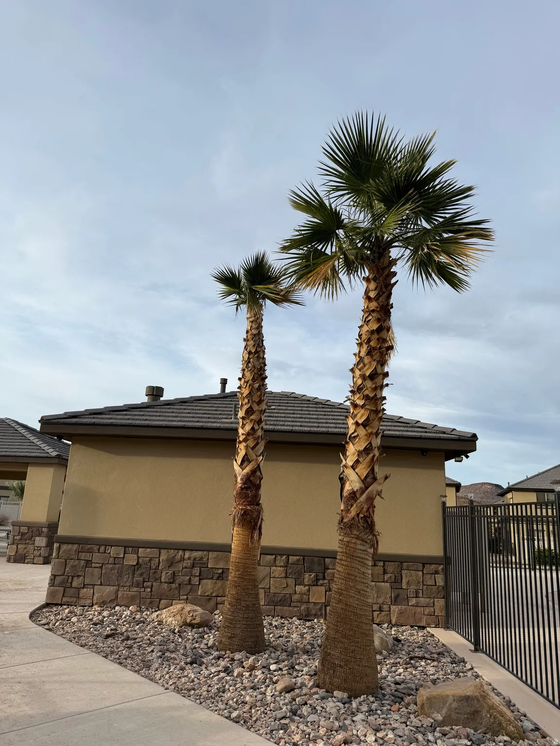 View of side of home featuring stone siding, stucco siding, and a tiled roof