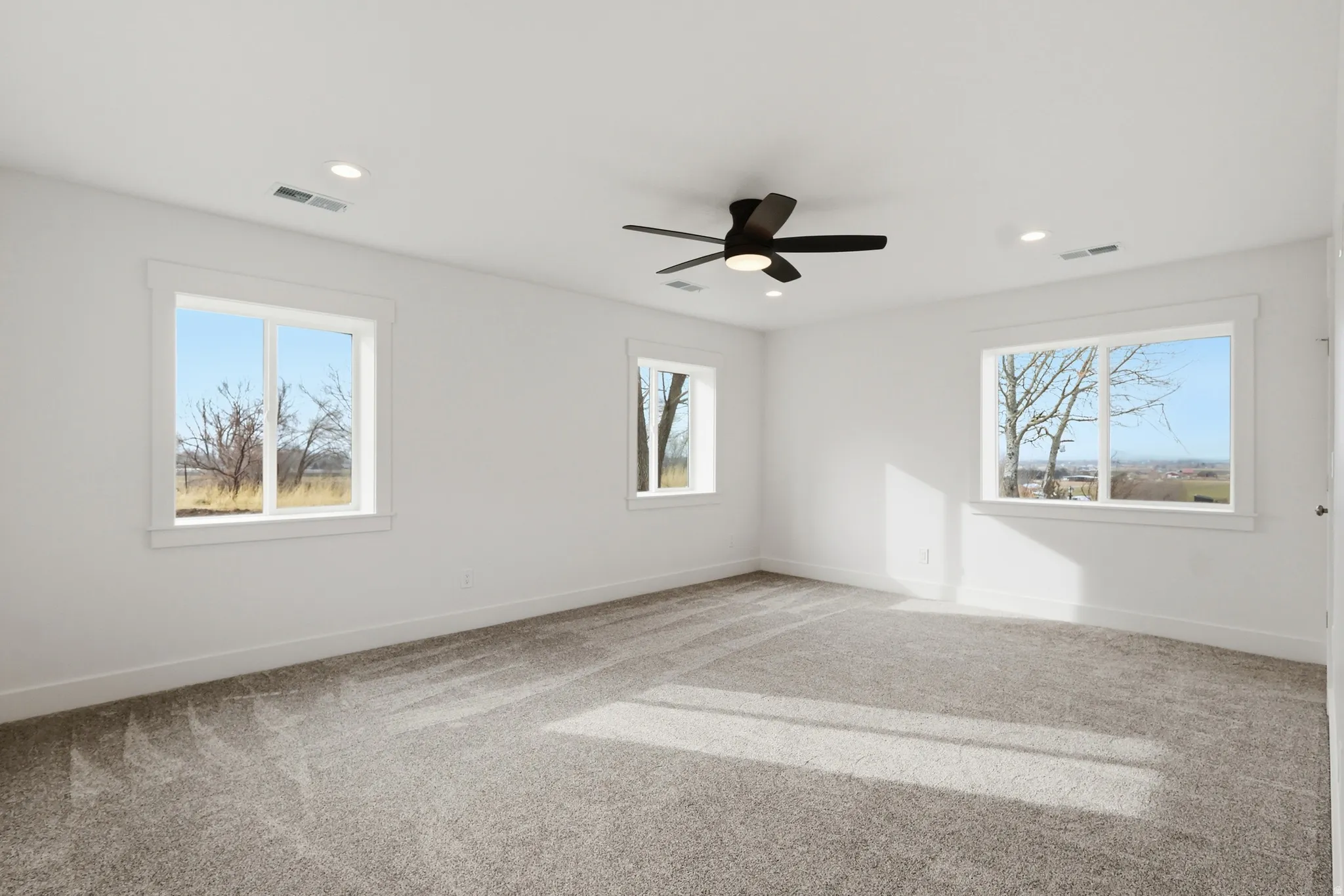 Master bedroom with large walk in closet, a ceiling fan, and recessed lighting