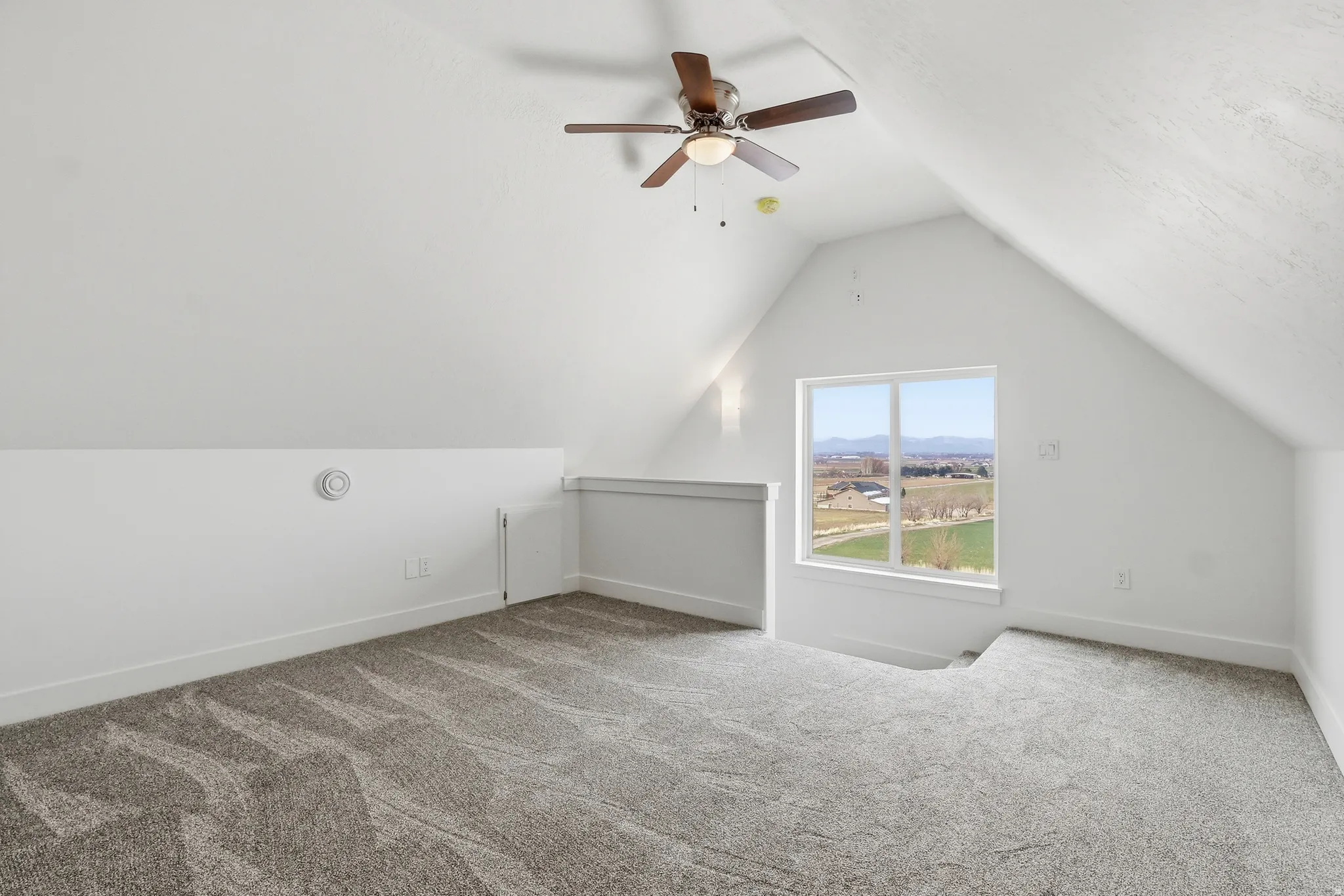 Upper level master suite featuring vaulted ceiling, light colored carpet, and ceiling fan