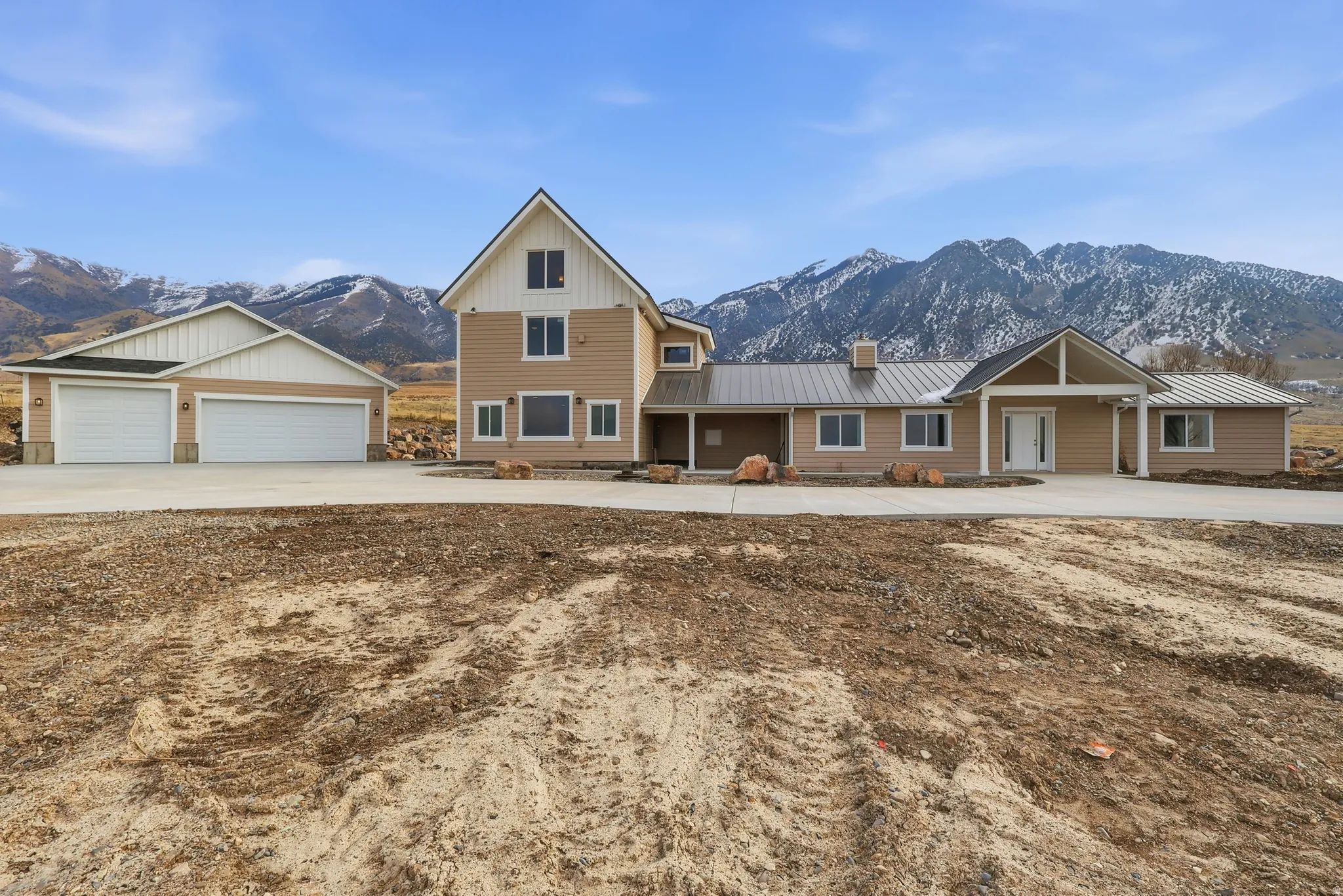 View of front of property with a metal roof, a mountain view, a garage, and concrete driveway