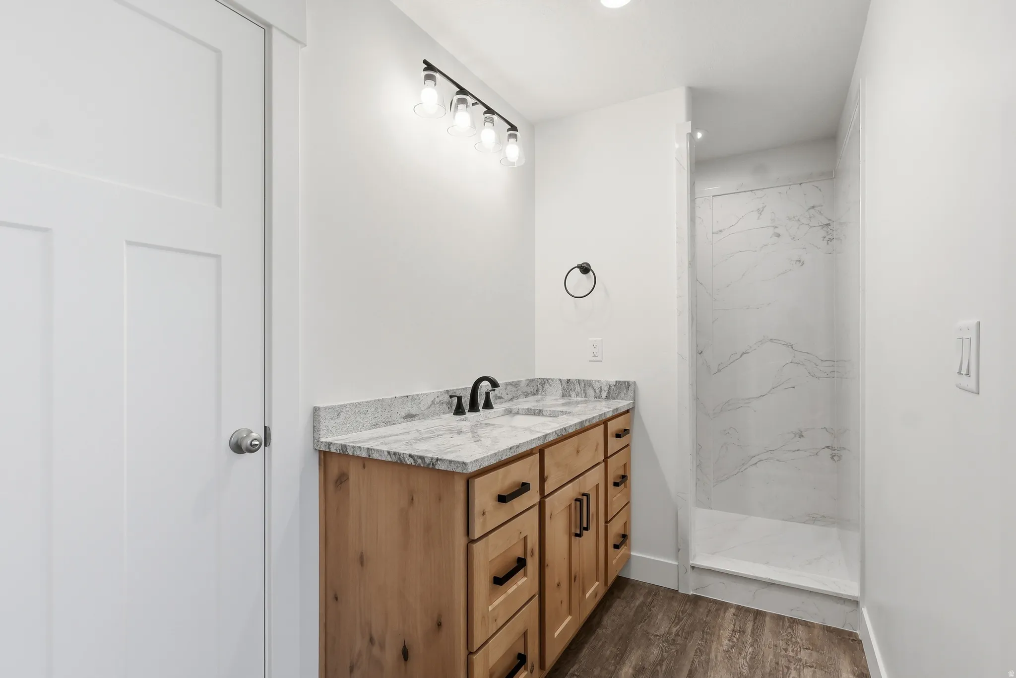 Full bathroom with vanity, a marble finish shower, and LVP floors