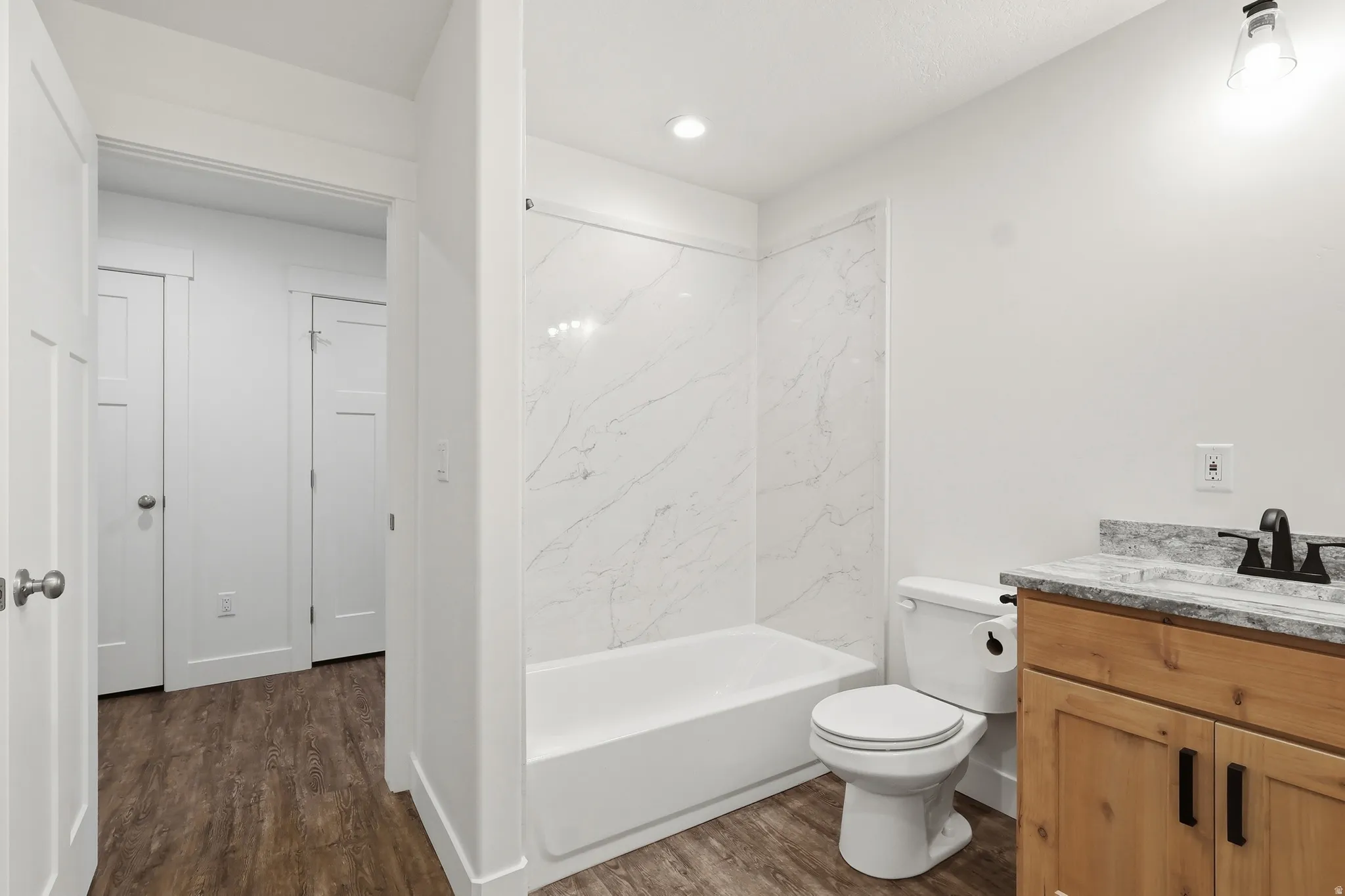 Full bath featuring vanity, dark wood-style flooring, and tub / shower combination