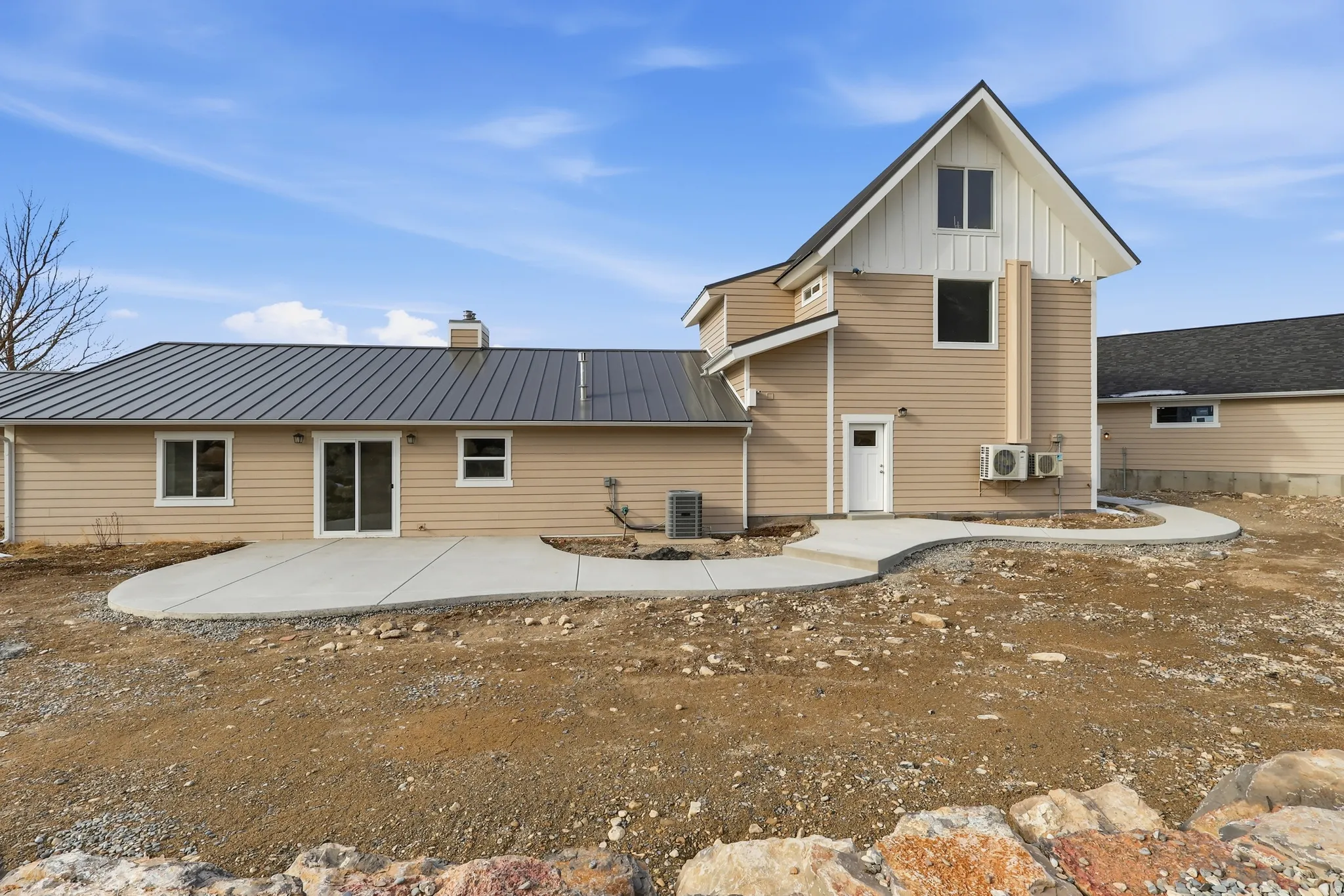 Rear view of house with a creative concrete patio