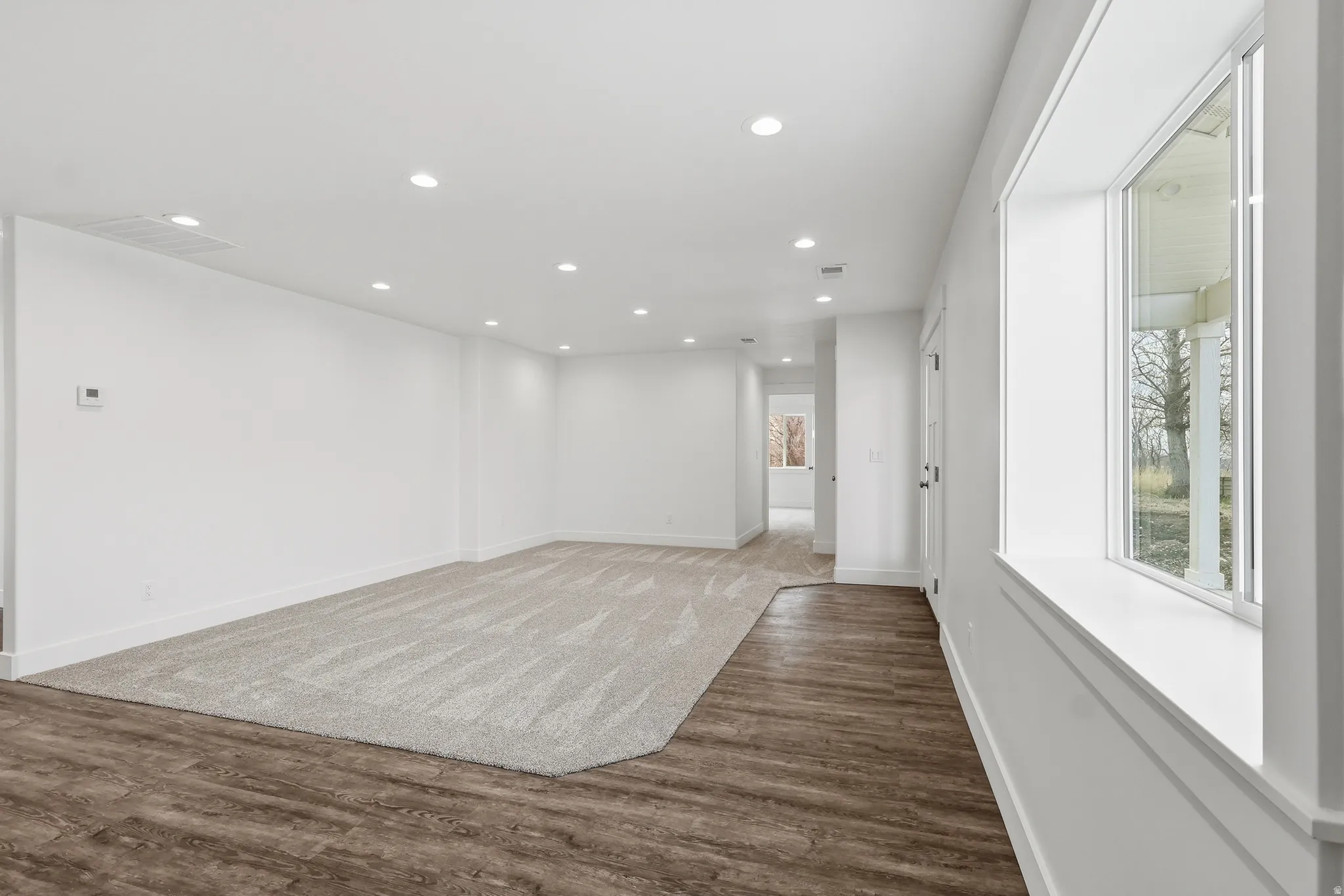 Living room featuring recessed lighting, carpet and LVP walkway.