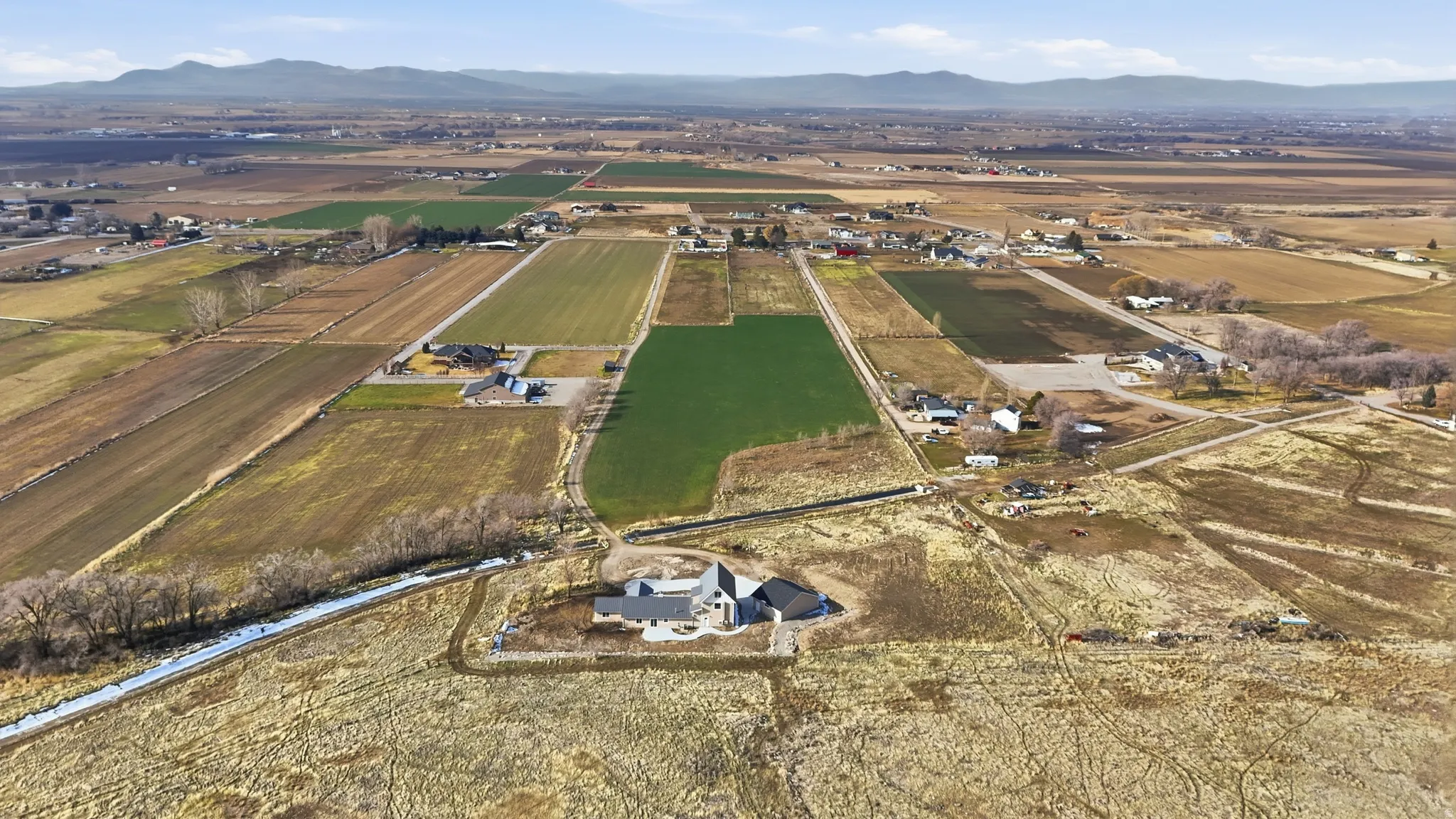 Aerial view of property and surrounding area featuring rural landscape and mountains