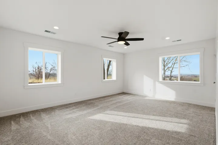 Master bedroom with large walk in closet, a ceiling fan, and recessed lighting