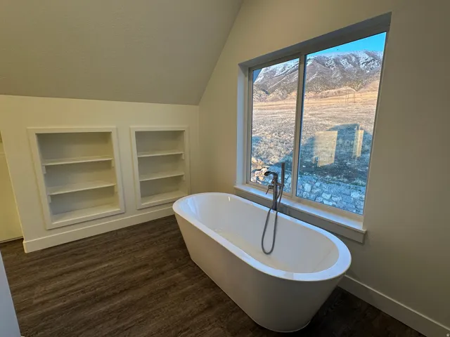 Bathroom with built in shelves, and freestanding tub.