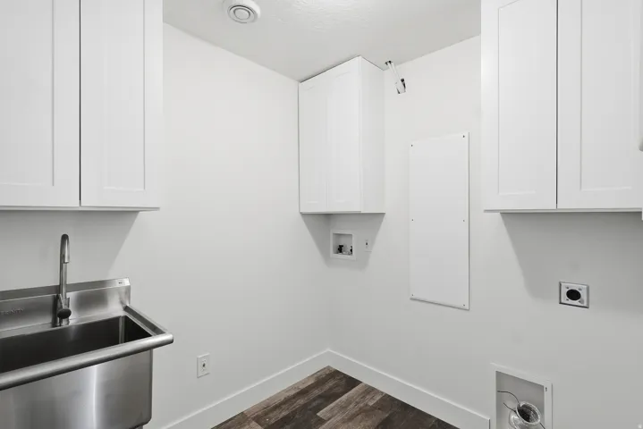 Laundry room featuring hookup for an electric dryer, hookup for a washing machine, cabinet space, and dark wood finished floors