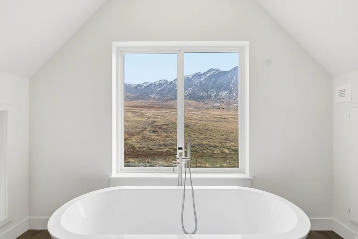 Bathroom with lofted ceiling, a freestanding bath,  and separate shower