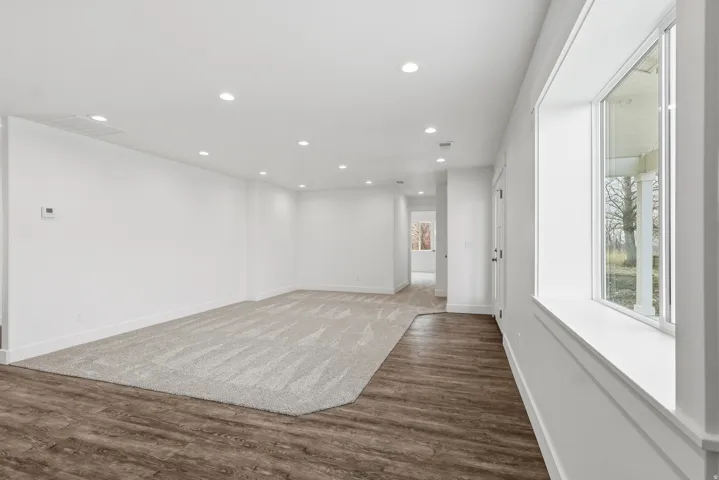 Living room featuring recessed lighting, carpet and LVP walkway.