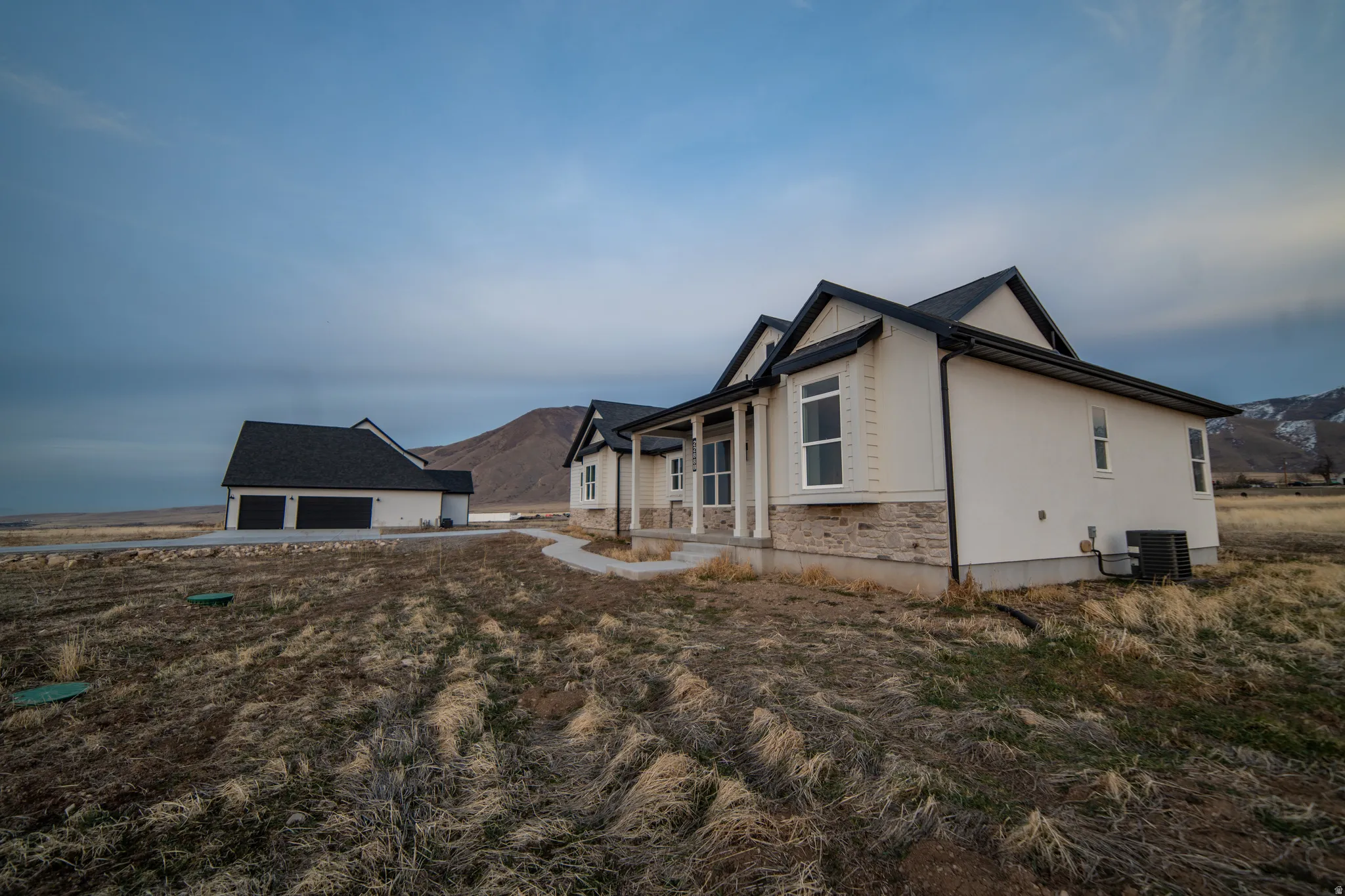 View of home's exterior featuring an outbuilding, stone siding, a mountain view, and stucco siding