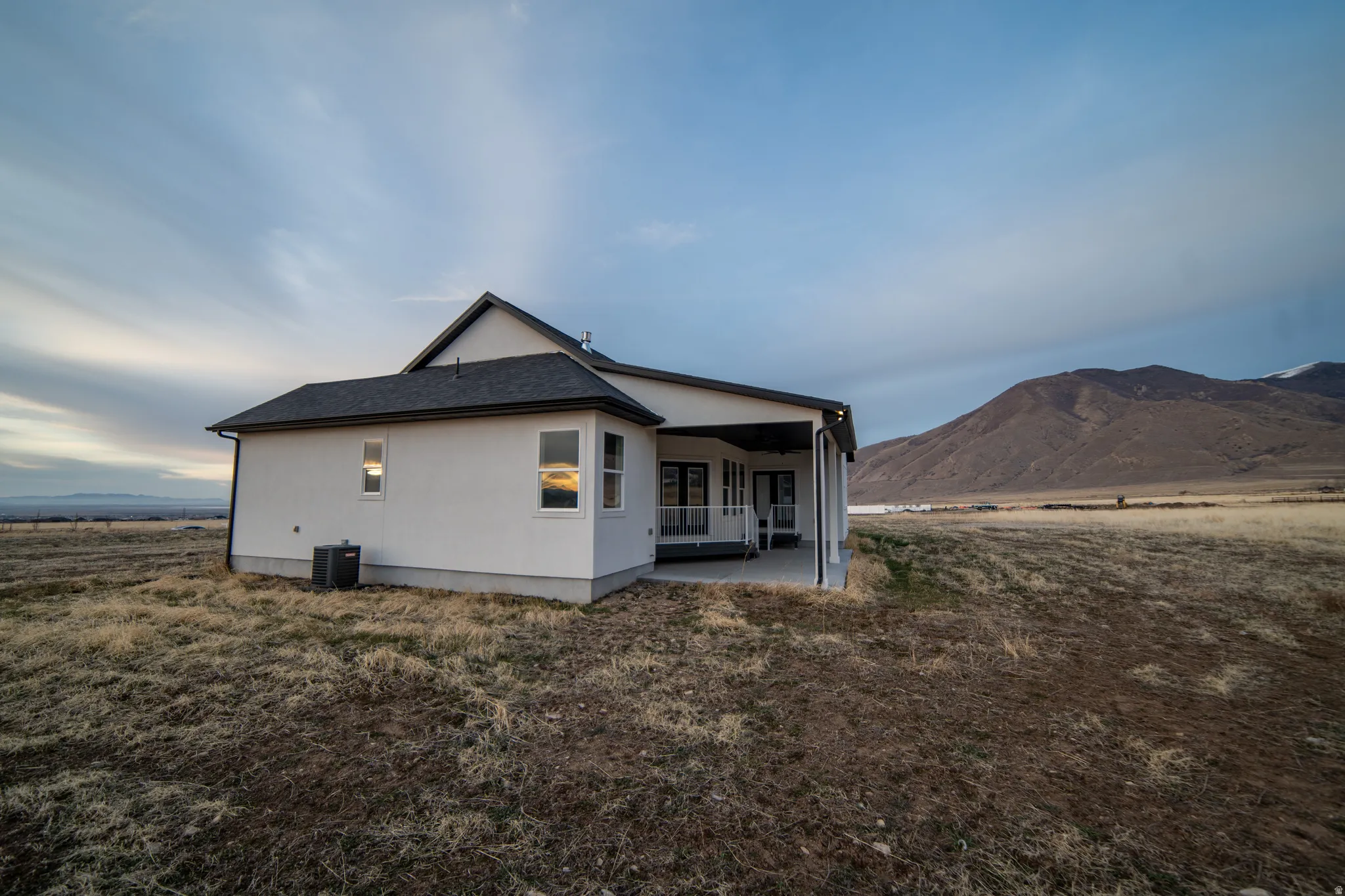 Back of house with a patio and a mountain view