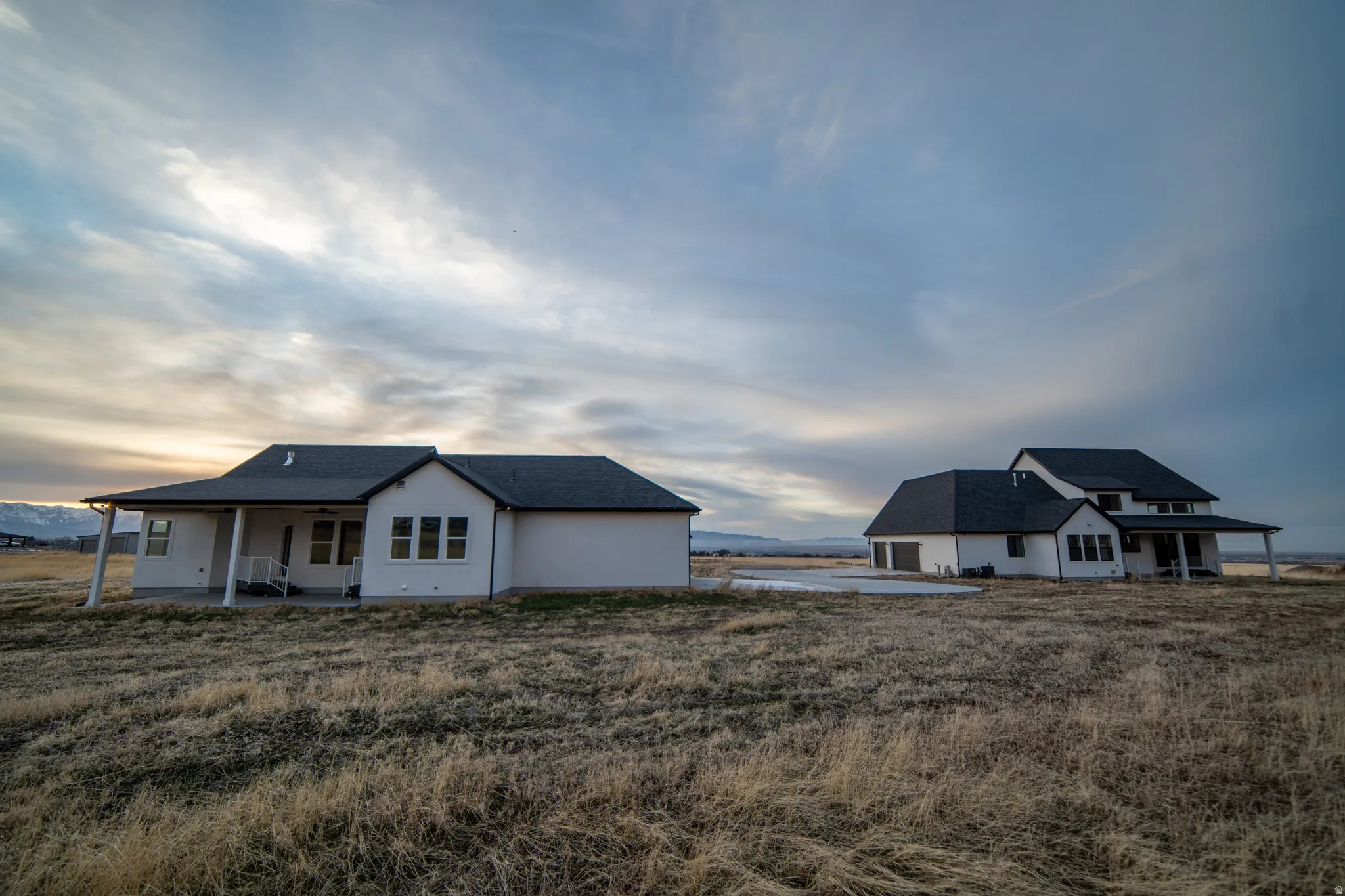 View of front of house with a patio and roof with shingles
