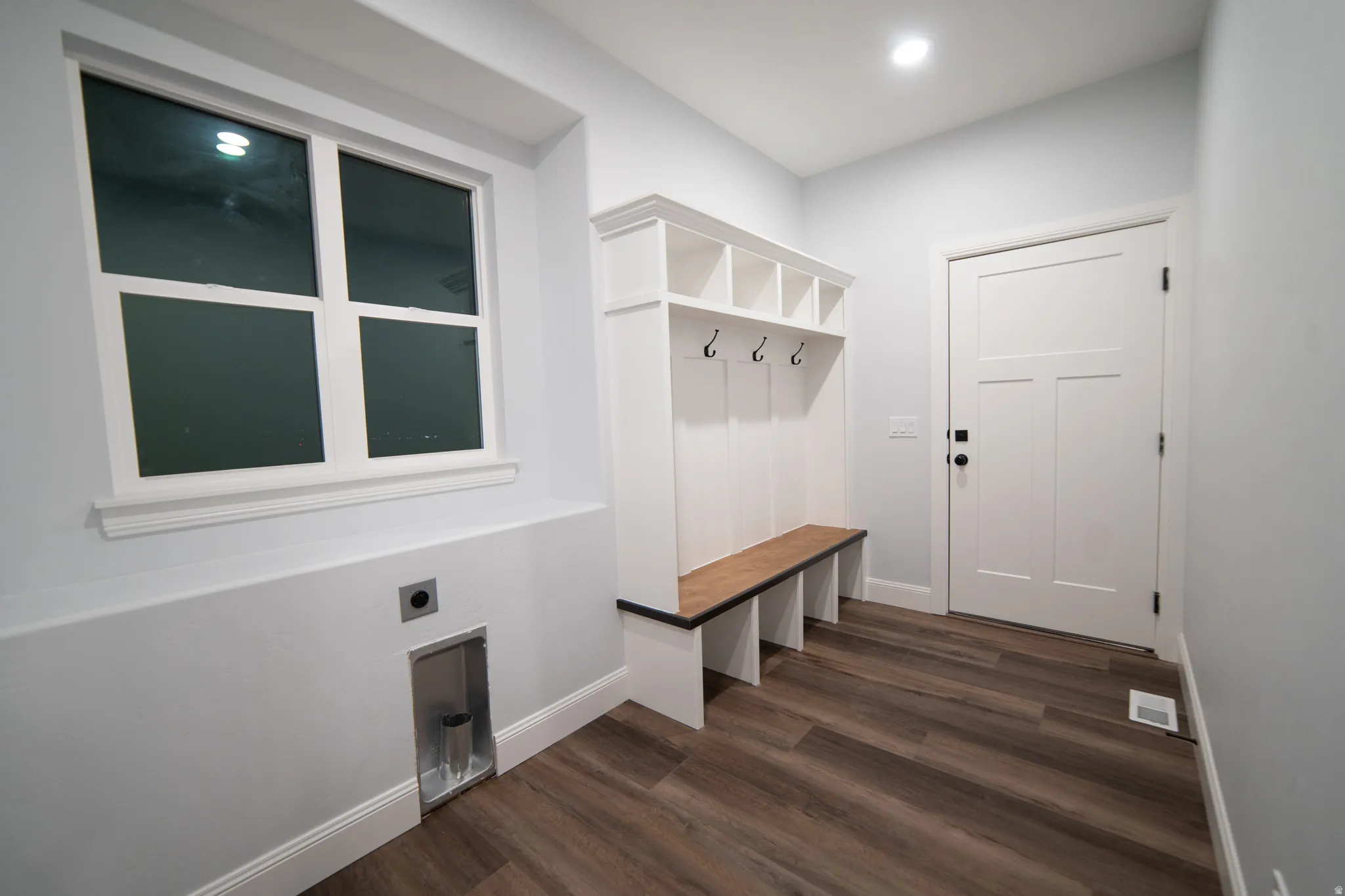 Mudroom featuring dark wood-style flooring and baseboards