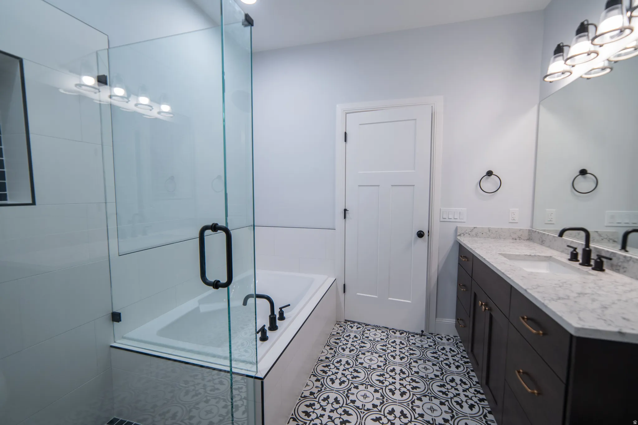Full bath with a bath, vanity, a shower stall, and light tile patterned flooring
