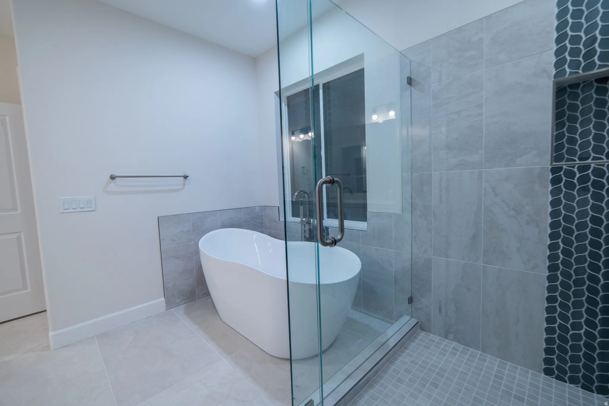 Full bath with a stall shower, tile patterned floors, and a freestanding tub