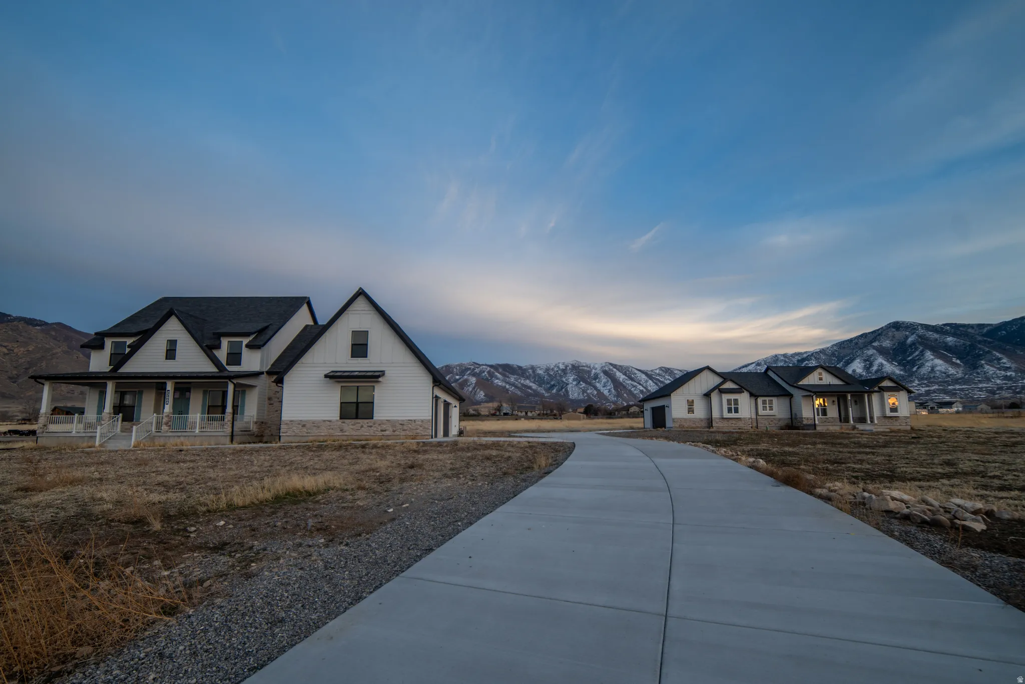 Modern farmhouse style home with a mountain view, a porch, and stone siding