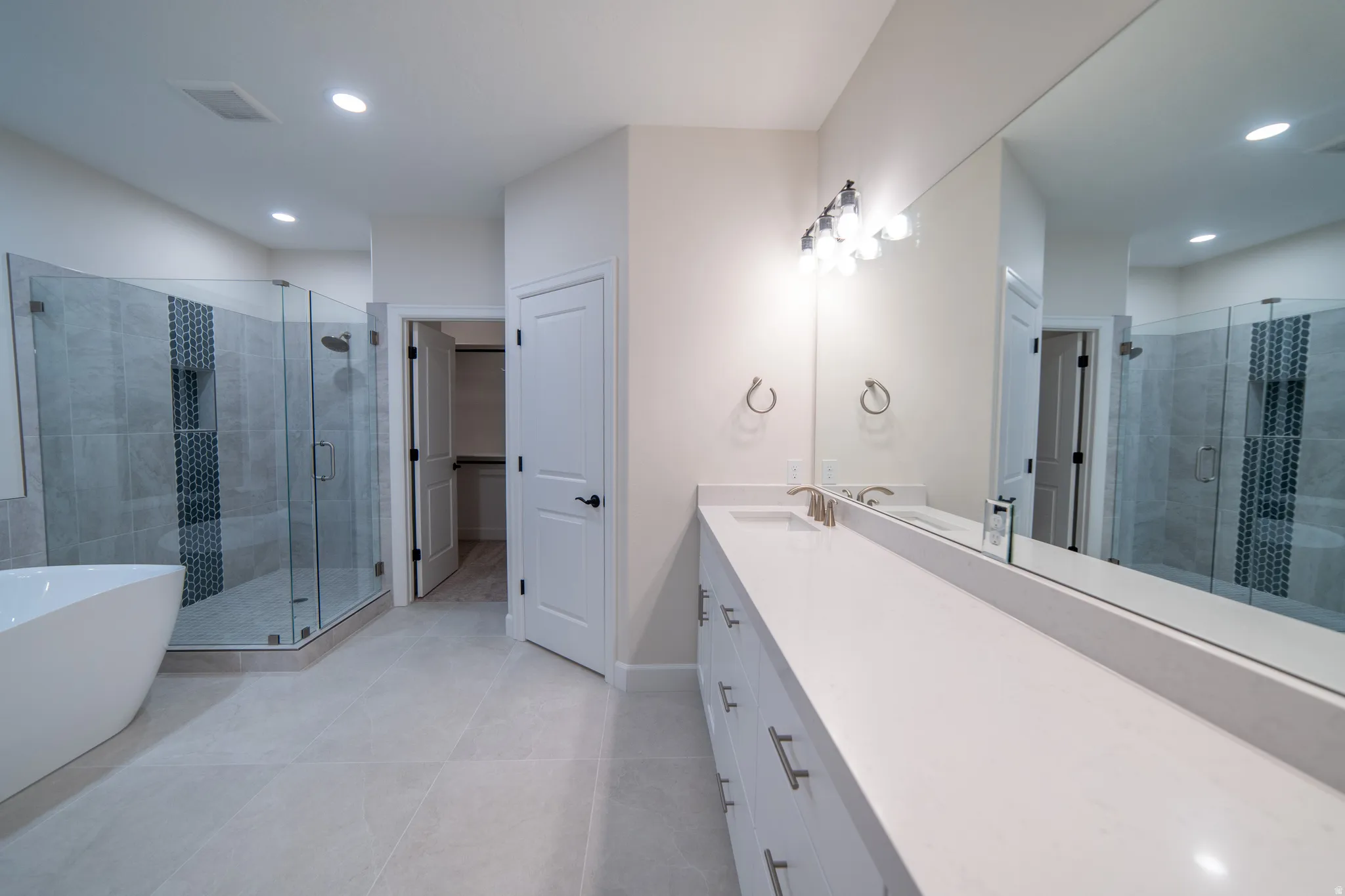 Bathroom with a shower stall, vanity, a soaking tub, recessed lighting, and light tile patterned floors