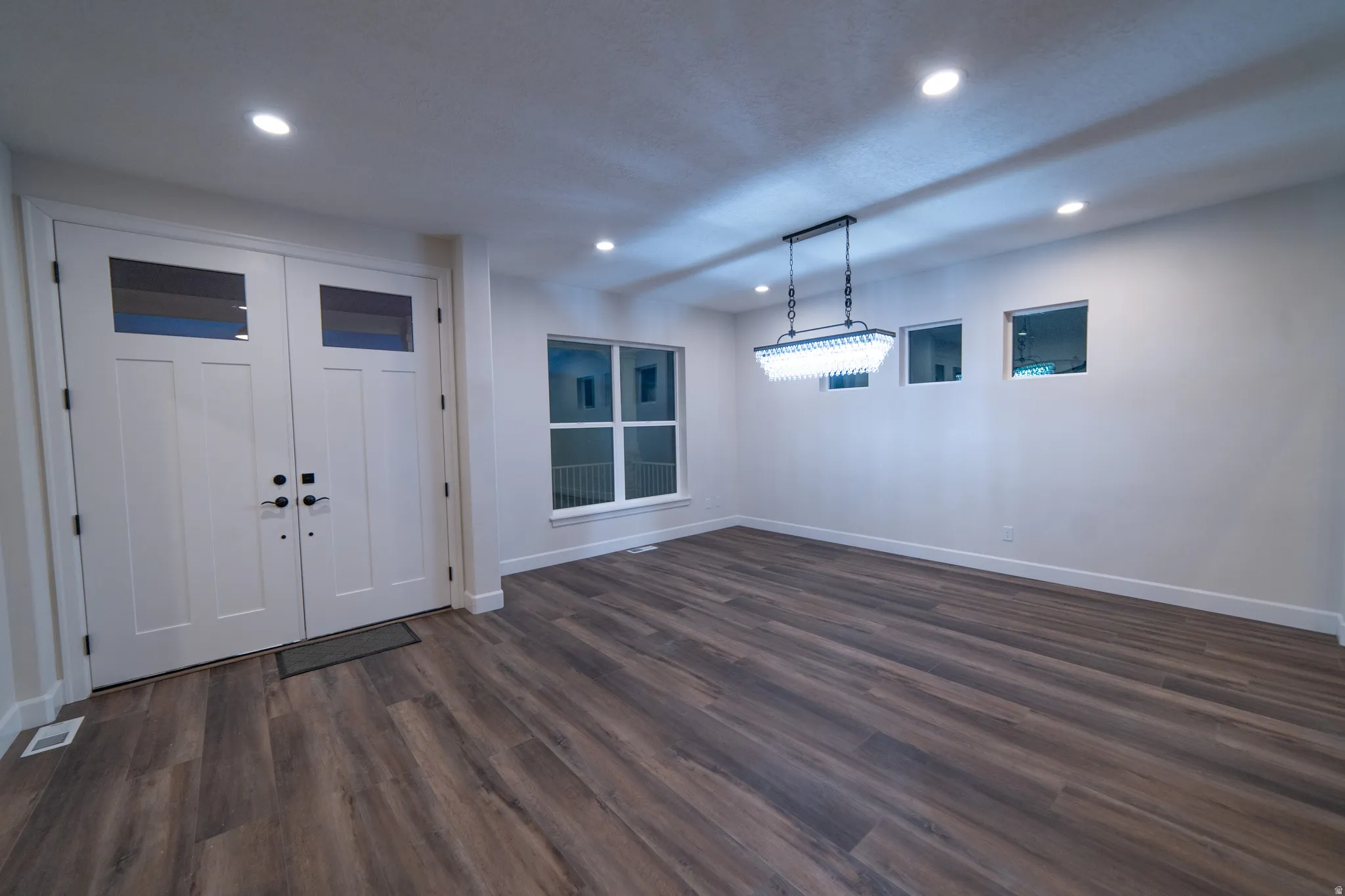 Foyer entrance with dark wood-style floors and recessed lighting