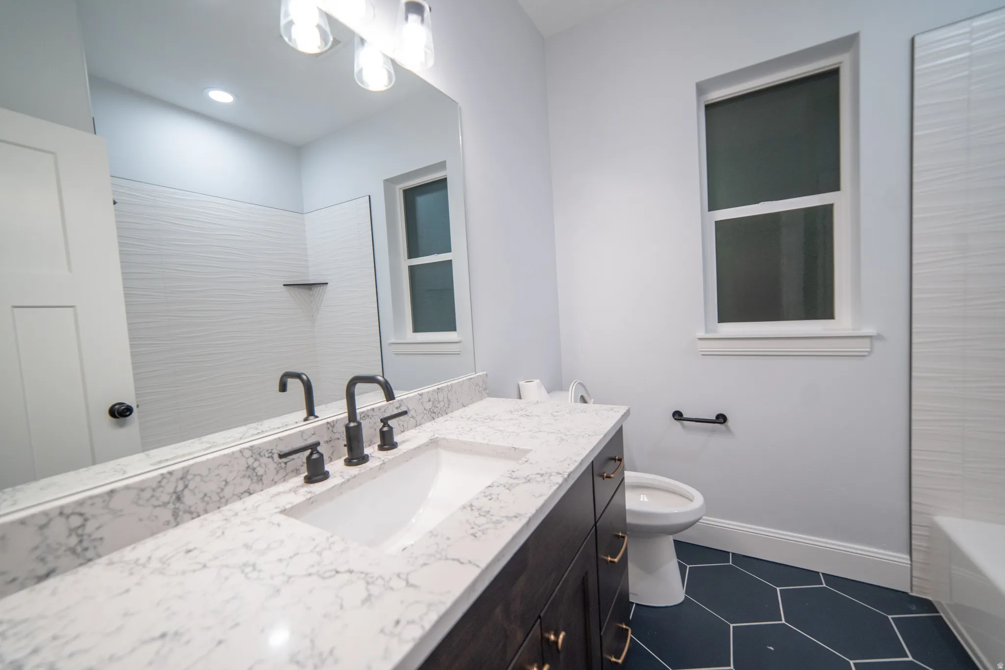 Bathroom featuring vanity and washtub / shower combination