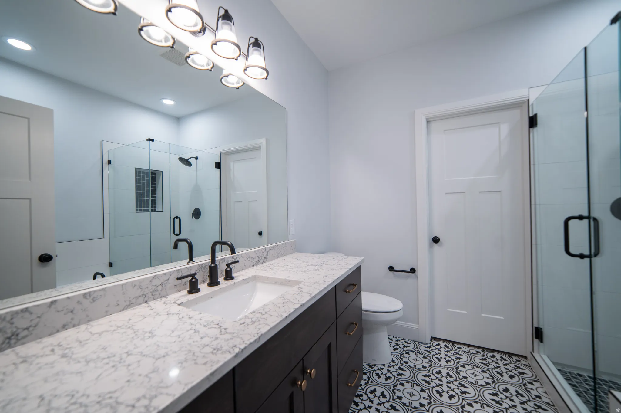 Bathroom with a stall shower, vanity, and light tile patterned floors