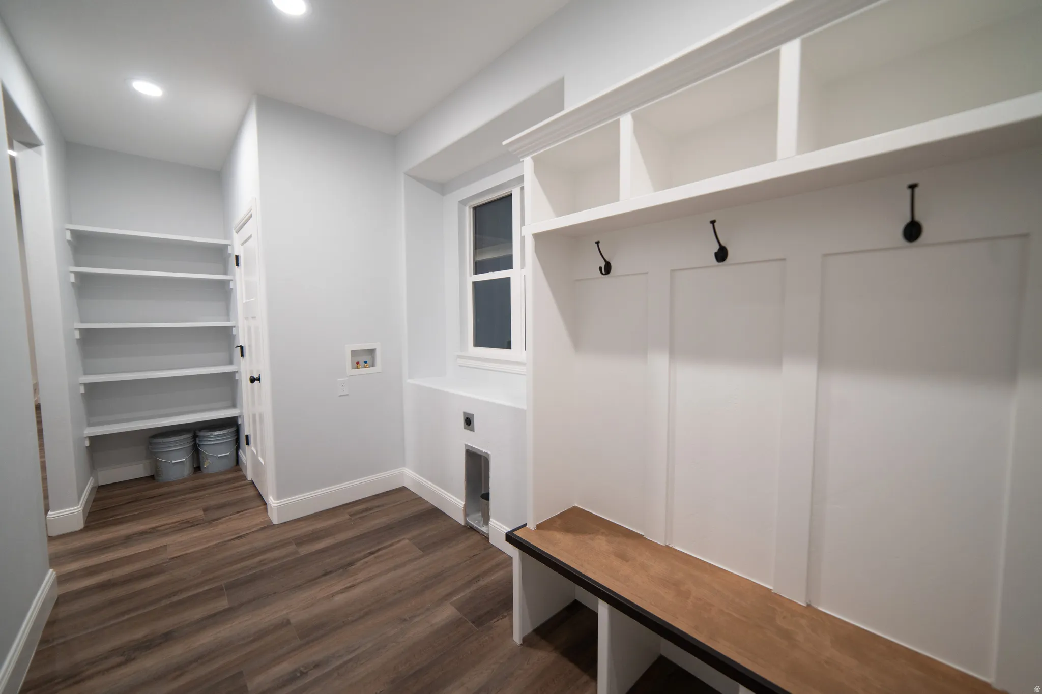 Mudroom with dark wood-style flooring and baseboards
