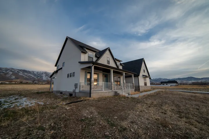 View of front of house featuring a mountain view, covered porch, and a shingled roof