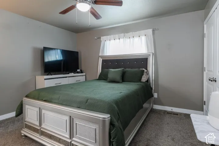 Primary bedroom with carpet flooring and ceiling fan
