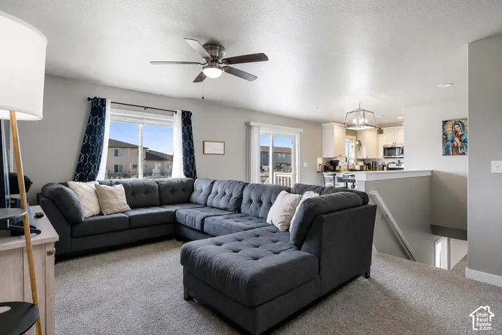 Open-concept living space featuring light gray walls and carpeted flooring