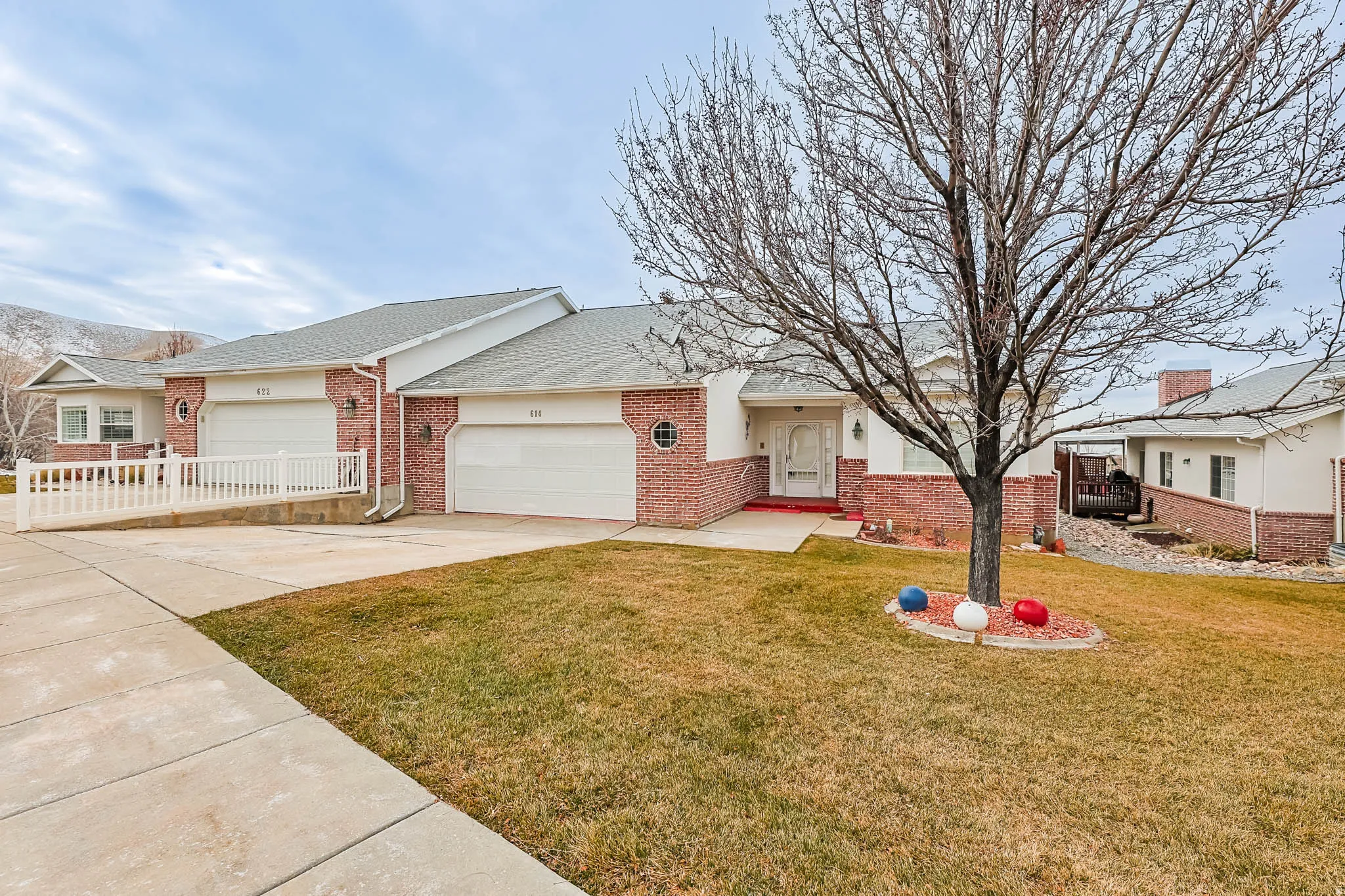 Single story home with concrete driveway, brick siding, an attached garage, and a shingled roof