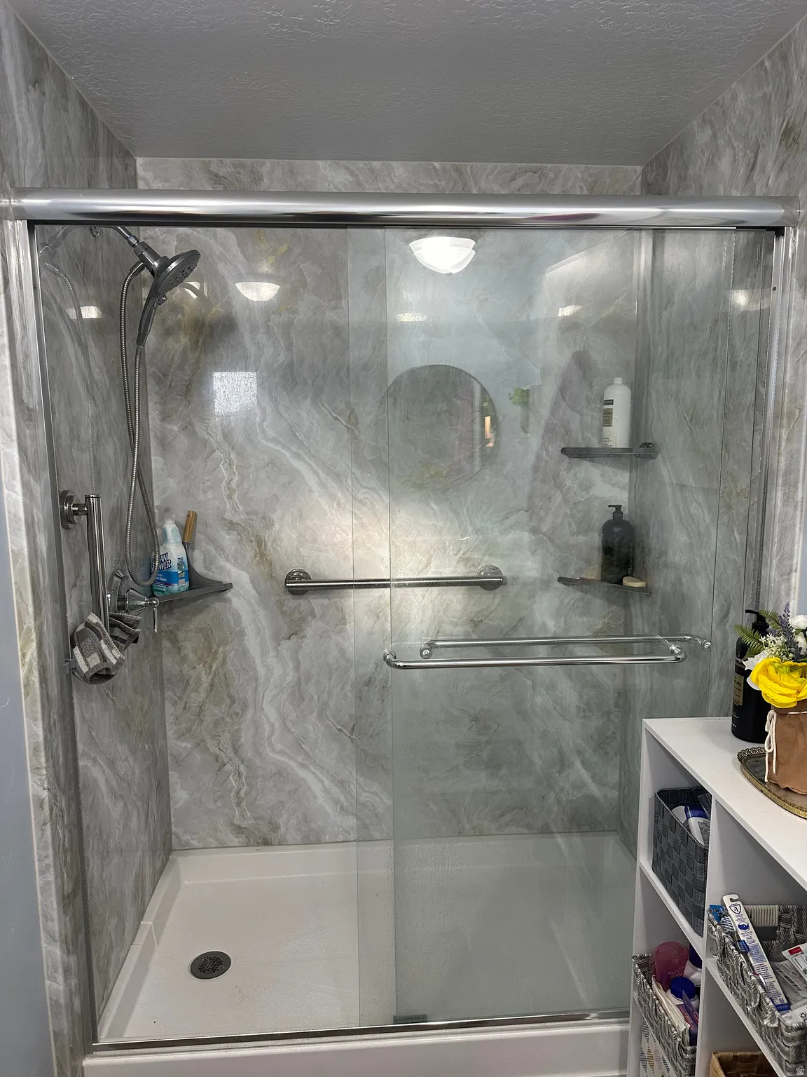 Full bathroom with a marble finish shower and a textured ceiling