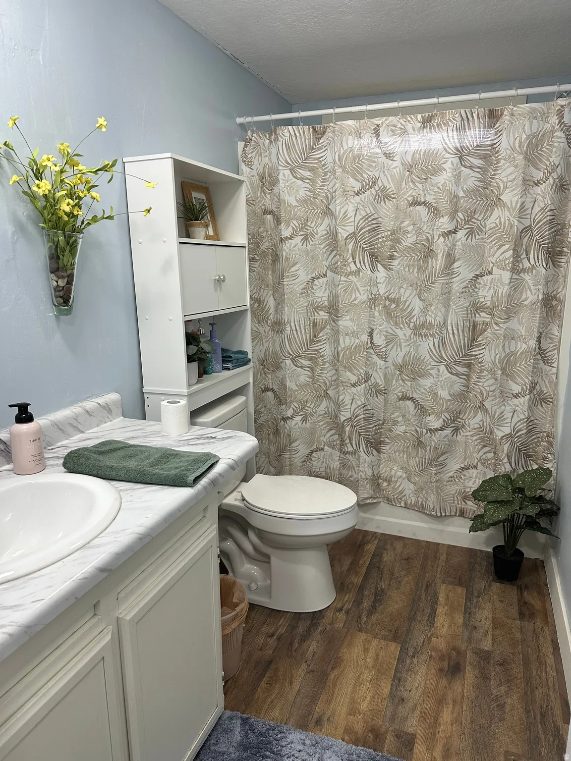 Bathroom with curtained shower, dark wood-style flooring, vanity, and a textured ceiling