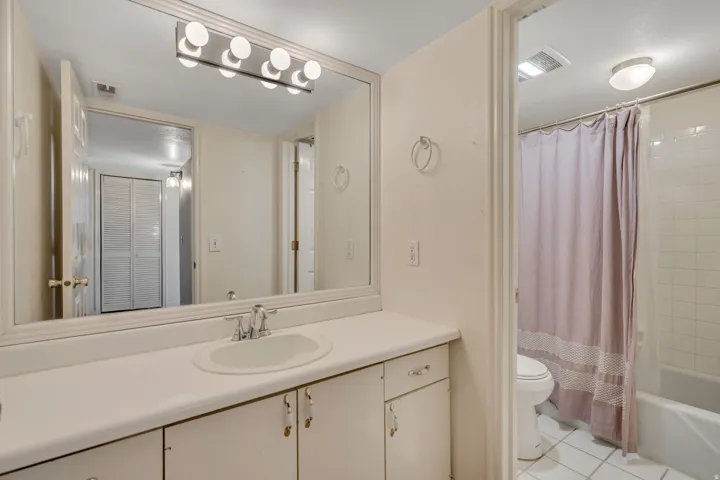 Full bathroom with shower / tub combo, vanity, and light tile patterned floors