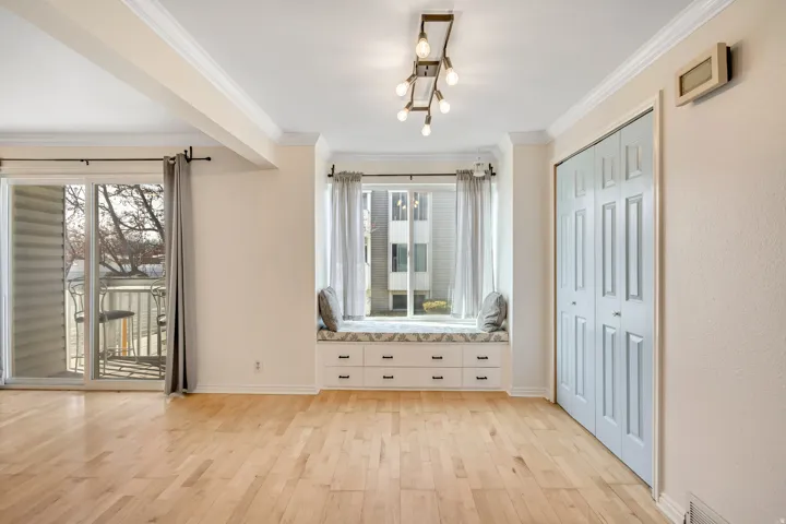 Interior space featuring light wood finished floors, crown molding, and healthy amount of natural light
