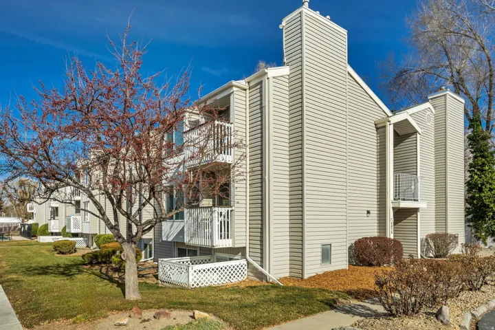 View of side of property with a chimney and a balcony
