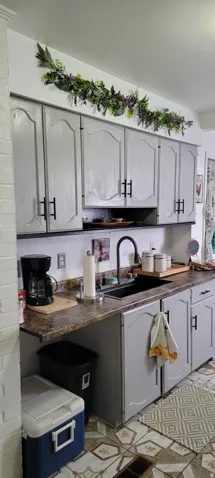 Kitchen with dark countertops, gray cabinets, and a textured ceiling