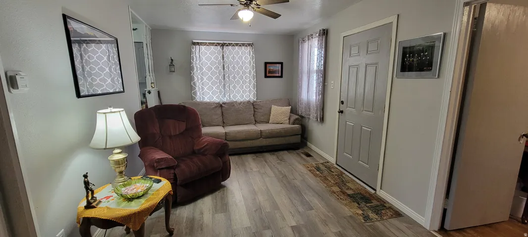 Living area with wood finished floors and ceiling fan