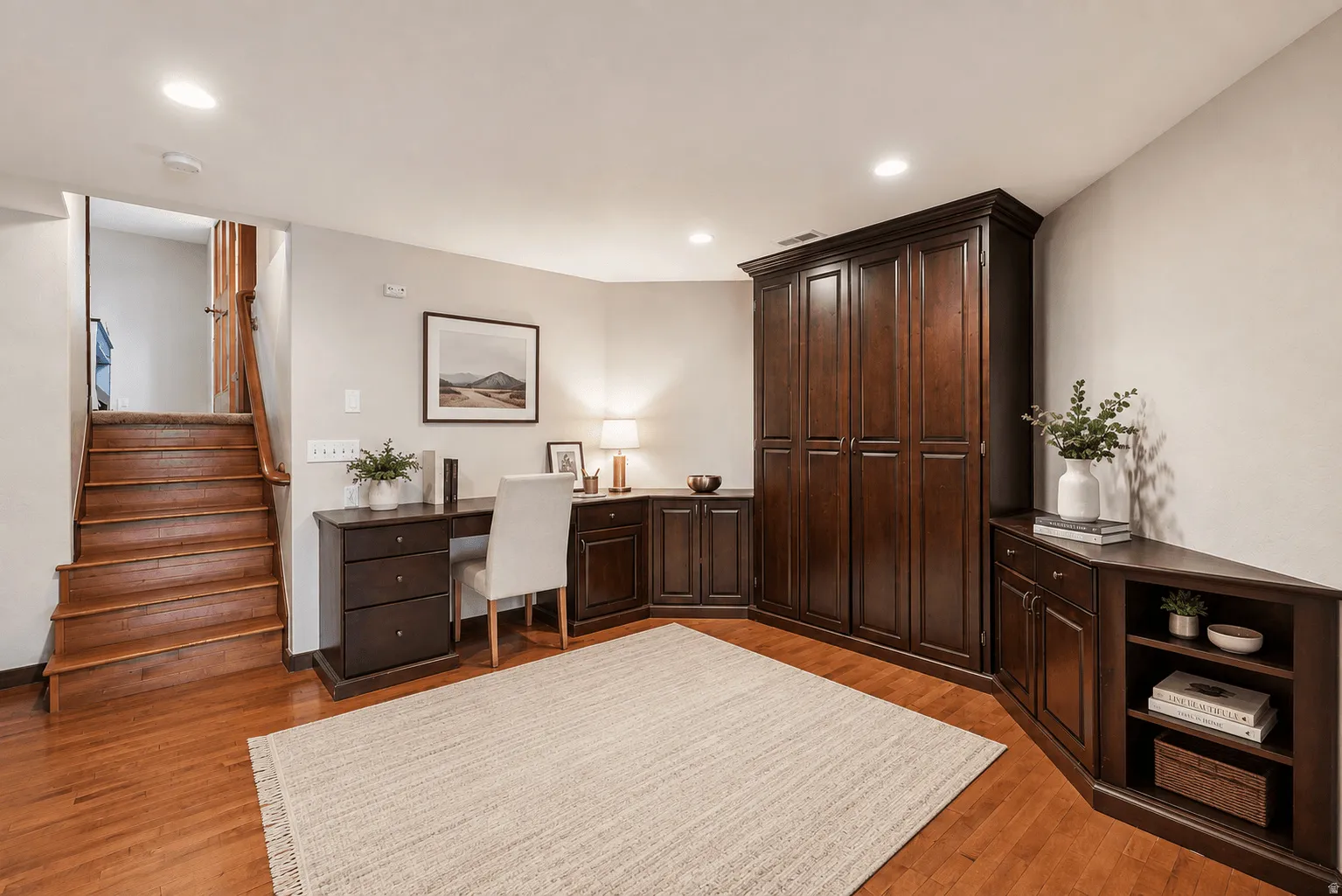 Hardwood flooring, recessed lighting, built-in cabinetry, built-in desk, and a wooden staircase with railing