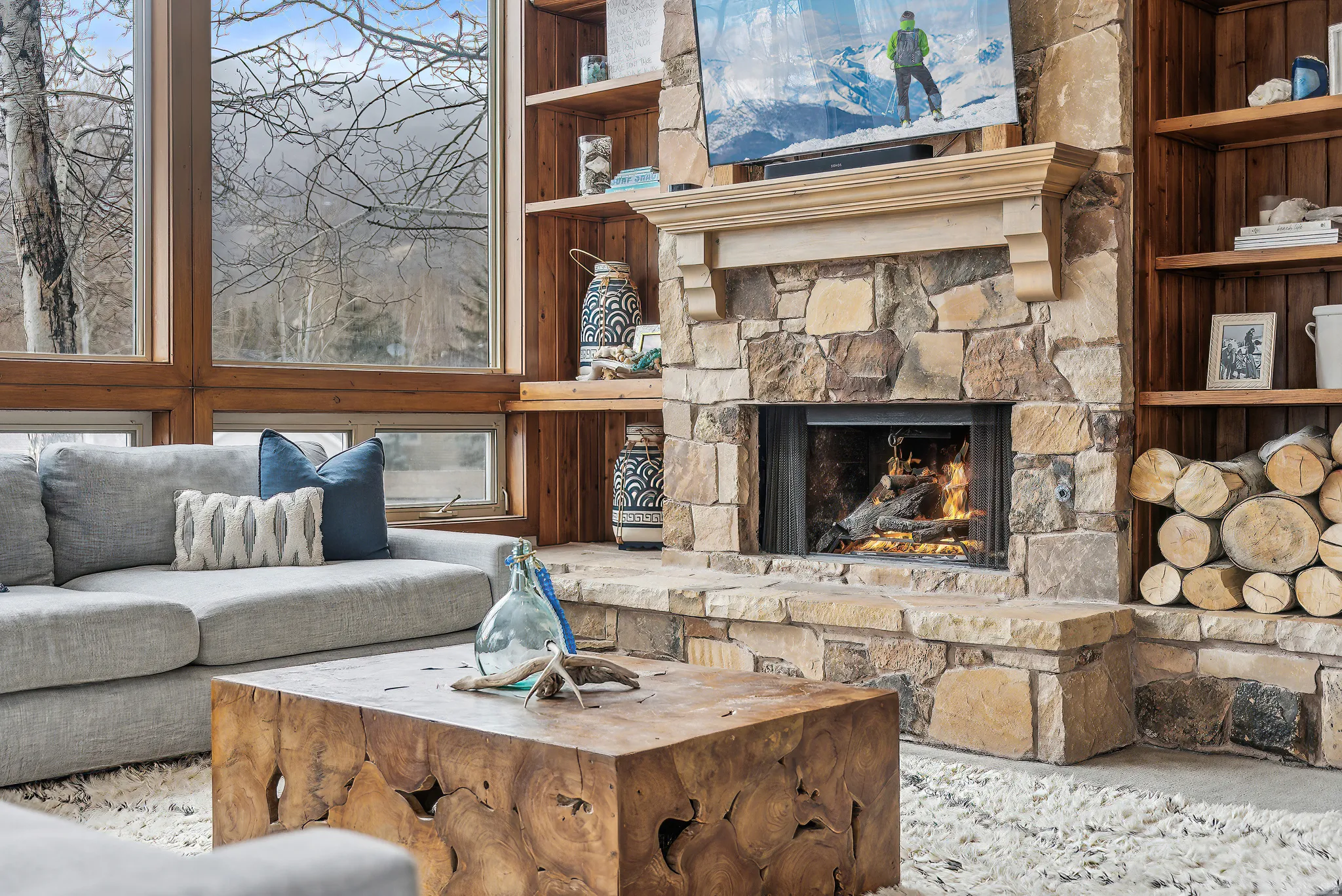 Stone fireplace with a light-toned mantel and integrated wood storage