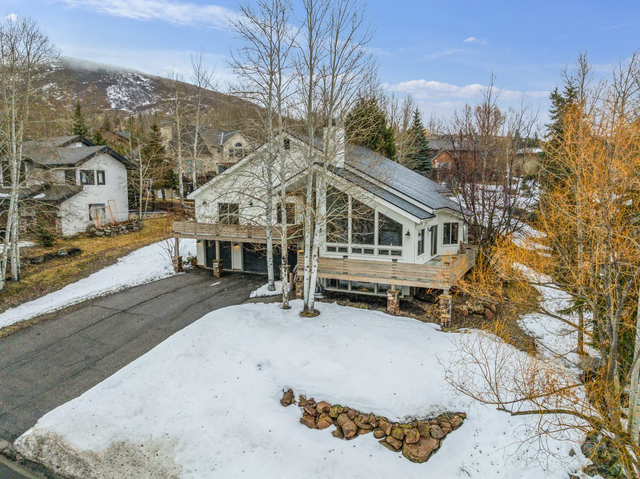 View of front of house featuring asphalt driveway and a chimney