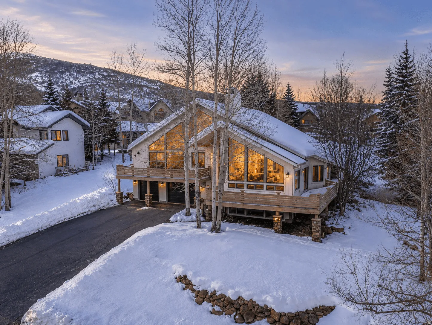 Modern A-frame architecture featuring extensive glass windows and a prominent balcony