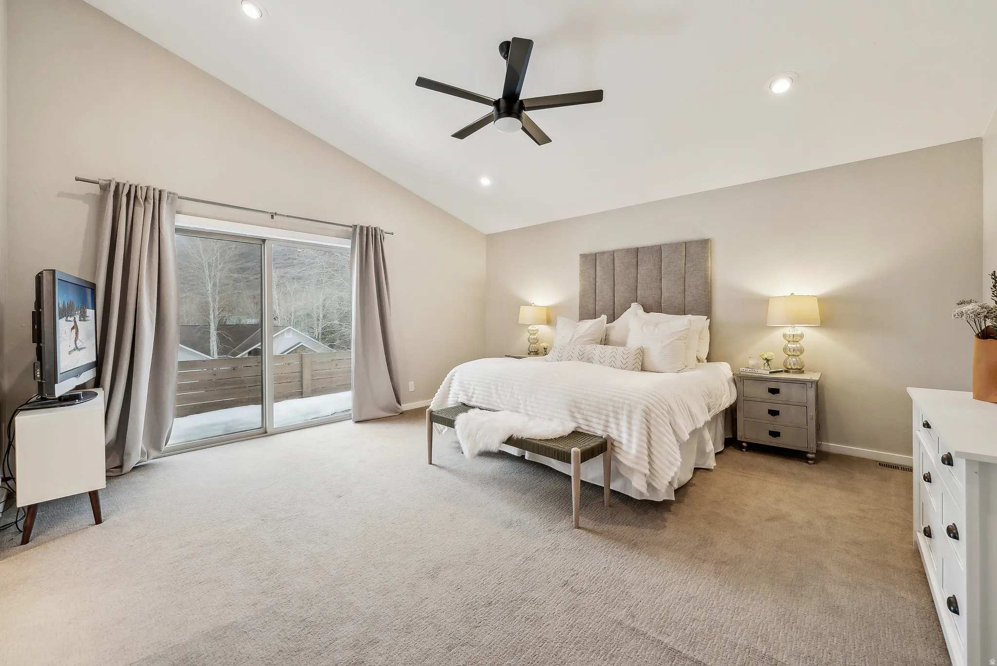Vaulted ceiling with recessed lighting and a ceiling fan